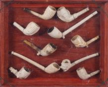 A framed collection of ten clay pipe bowls, late 19th and 20th century,