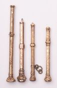 A group of four Victorian yellow or gilt metal seal top propelling pencils.