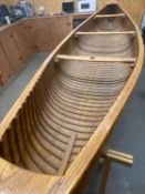 An early 20th century Canadian cedar strip canoe of traditional construction with three seats,