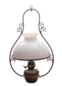 A late Victorian brass and milk glass hanging oil lamp, circa 1900; the domed shade with open vent,