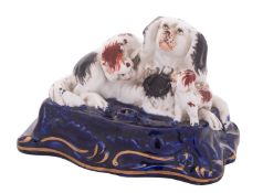 A Staffordshire porcelain 'spaniel family' inkwell in the form of a spaniel and two pups,