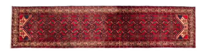 A Malayer runner, the brick red field with an all over geometric design,