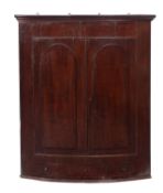 A Regency mahogany bowfront hanging corner cabinet,