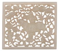 A Chinese celadon jade reticulated plaque carved with a mythical creature amongst cloud scrolls and