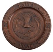 A Russian carved beech bread platter, early 20th century; the tondo with a wheatsheaf, a flail,