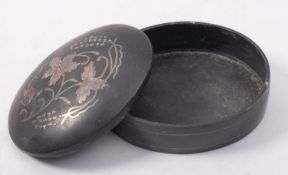 A bronze and silver inlaid oval box and