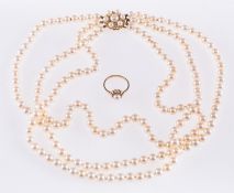 A pearl necklace and a pearl ring, a triple row of cultured pearls,