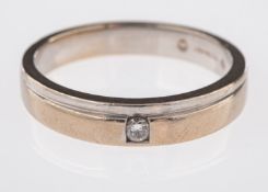 An 18ct white gold wedding band, set with a brilliant-cut diamond, 0.