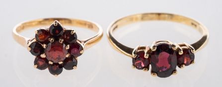 Two 9ct yellow gold garnet rings, to include a flowerhead ring set with circular-cut garnets,