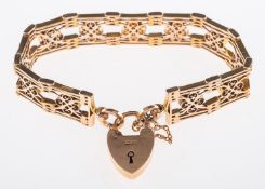 A fancy link gate bracelet of openwork articulated design with a heart padlock clasp and safety
