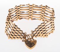 A 9ct yellow gold gate bracelet, with heart padlock and safety chain, UK hallmark, length approx.