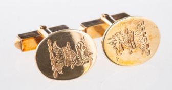 A pair of cufflinks, of oval design with crest engraving,
