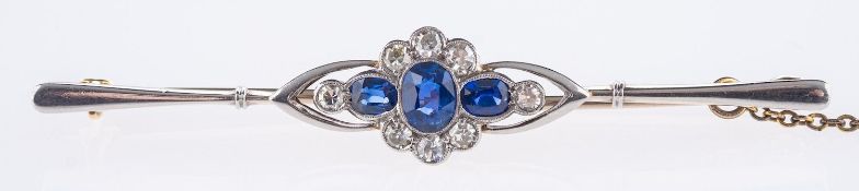 An Edwardian bar brooch, of flowerhead design and set with three oval-cut sapphires,