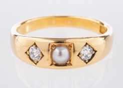 A three stone ring, centrally set with a pearl and an old mine-cut diamond to each side,