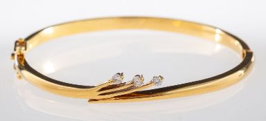 A diamond bangle, designed with a spray of three brilliant-cut diamonds, hinged, (hinge broken),