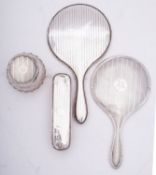 A matched silver backed dressing table set comprising of a silver and glass powder jar,