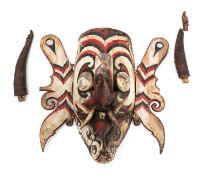 A Borneo carved painted mask of a demonic face