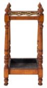 An oak and brass stick stand, circa 1900, with six circular divisions,