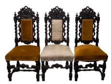 A set of three carved oak hall or dining chairs in the Carolean style,