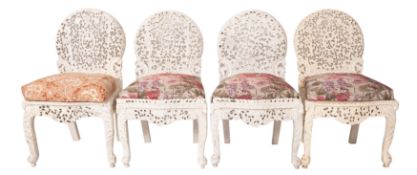 A set of four Anglo Indian carved hardwood and upholstered side chairs,