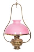 A late Victorian/Edwardian brass hanging oil lantern, with pink opaque glass shade,