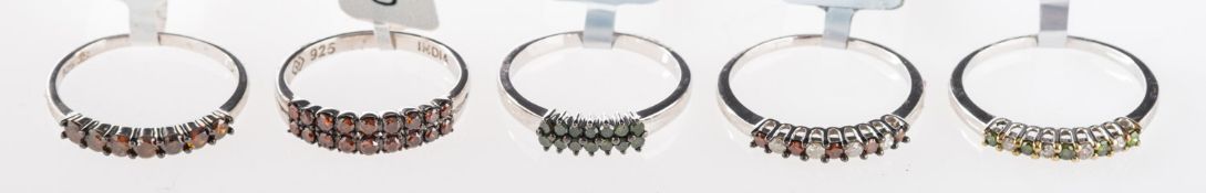 A group of five silver rings, set with r