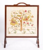 A mahogany framed crewelwork fire screen