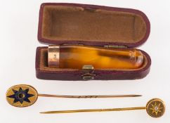 Two stick pins and a cheroot holder, two