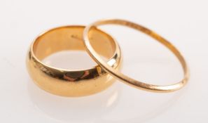 Two wedding bands, both unmarked, the wide band tests as 18ct gold, size K1/2, 8.
