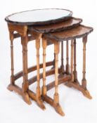 A nest of three walnut and burr walnut oval occasional tables, in early 19th century style,