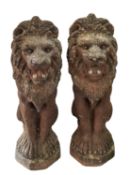 A pair of painted reconstitued stone garden models of lions,