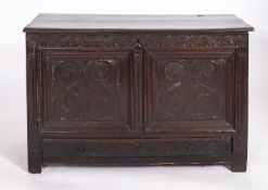 A Charles II oak coffer, circa 1660, the hinged plank lid notched at the sides,