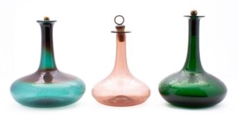 A group of three 19th century green and pale amethyst glass Mell decanters one engraved with vines,