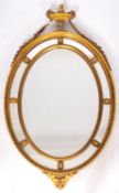 A carved and gilt composition framed marginal oval wall mirror, in Regency style,