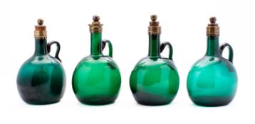 A group of four 19th century green glass flagon decanters with brass mounted rims and stoppers,