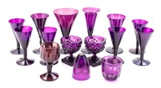 A group of amethyst coloured glassware comprising a set of six wine glasses with plain funnel bowls,
