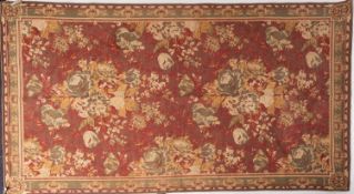 A machine made tapestry, in Savonnerie style, the beige field with a design of floral sprays,