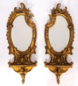 A pair of gilt composition mirrored wall brackets, in Louis XV taste,