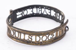 An early 18th Century pierced brass dog collar with rolled edge and four adjustment slots,