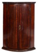 A George III oak walnut banded hanging corner cupboard,