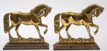 A pair of brass and iron mounted door porters cast as horses,