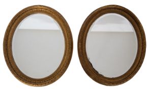 A pair of Victorian gilt composition framed oval wall mirrors,