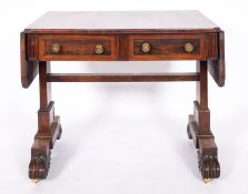 A Regency rosewood sofa table, circa 1815; the twin drop leaves with rounded corners,