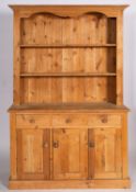 A pine dresser in 19th century style, 20th century; the upper section with cornice and open shelves,
