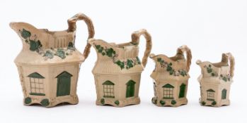 A graduated set of four Staffordshire drab-ware 'cottage' jugs the highlights enameled in green,