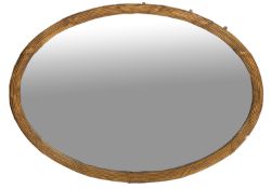 A carved and giltwood oval framed wall mirror in George III style,