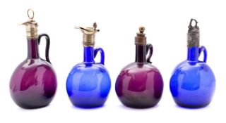 A group of four 19th century amethyst and blue glass flagon decanters with brass and plated mounts