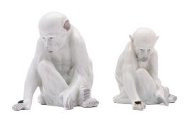 Two Gebruder Heubach porcelain figures of a seated monkey observing a fly on the back of its hand,