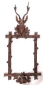 A 'Black Forest' carved and stained wall mounting hall rack, probably Swiss,