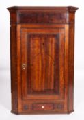 A George III oak and mahogany hanging corner cabinet.